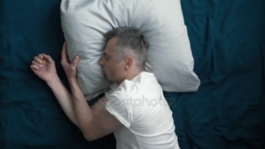 Bir adam zor bir günün ardından uykuya dalıyor.