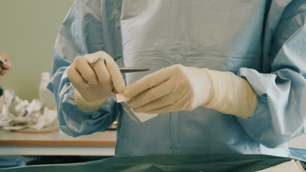 Γιατρός φοράει προστατευτική ενδυμασία εκτέλεση χειρουργικής χρησιμοποιώντας αποστειρωμένο εξοπλισμό — Αρχείο Βίντεο