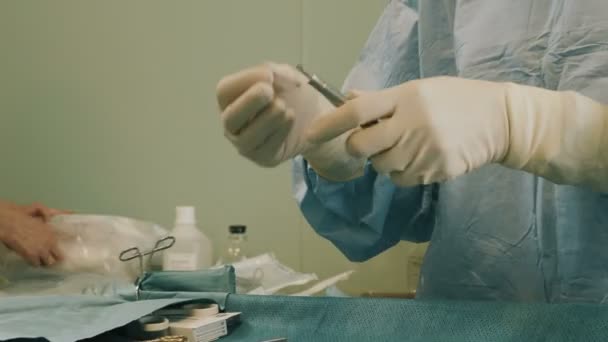 Médico vestindo roupas protetoras realizando cirurgia usando equipamentos esterilizados — Vídeo de Stock