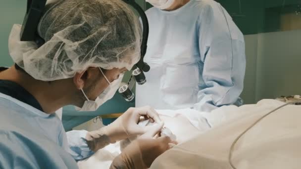 Arts het dragen van beschermende kleding uitvoeren met behulp van de chirurgie apparatuur gesteriliseerd — Stockvideo
