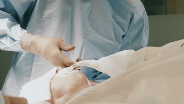 Médico usando ropa protectora realizando cirugía usando equipo esterilizado — Vídeo de stock