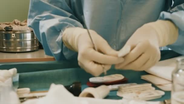 Doctor wearing protective clothing performing surgery using sterilised equipment — Stock Video