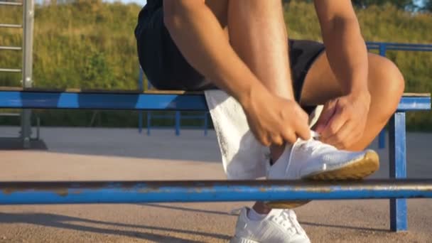 Легкоатлет завязывает кружева на обуви — стоковое видео