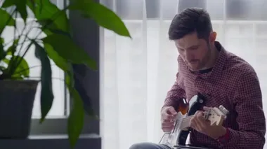 Adam gitar çalıyor.