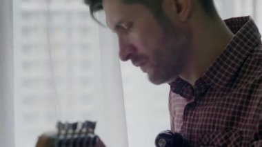 Adam gitar çalıyor.