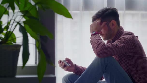 Detailní seriózní obchodní muž čtení špatné zprávy na telefonu doma interiéru. — Stock video