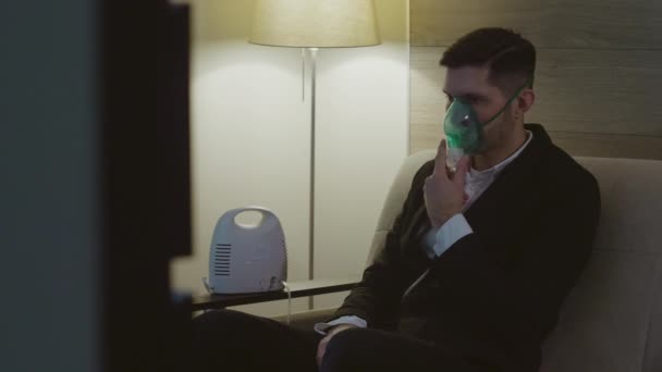 Een persoon inhaleert via een inhalator masker — Stockvideo