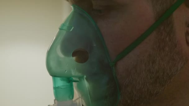 Een persoon inhaleert via een inhalator masker — Stockvideo