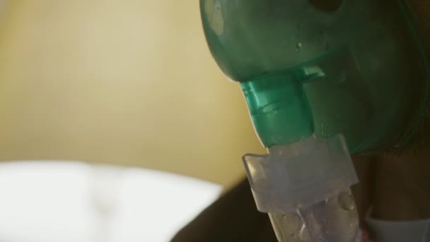 Человек вдыхает через маску ингалятора — стоковое видео