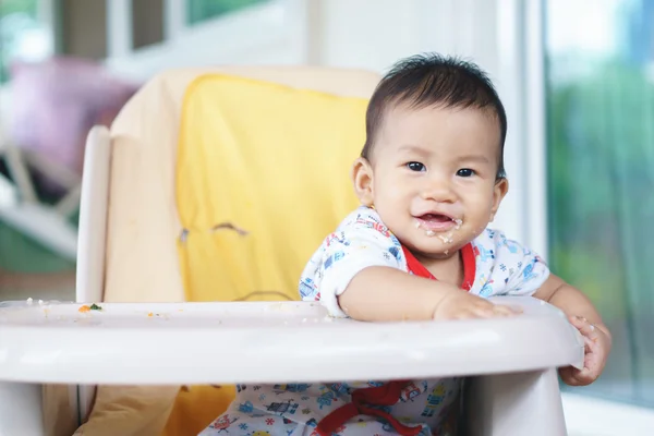 Asiático bebê comer comida por si mesmo — Fotografia de Stock