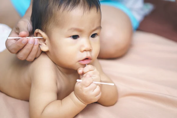 Mãe mão limpeza bebê orelha — Fotografia de Stock