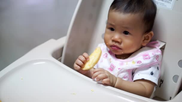 Asiático bebé comer comida por sí mismo — Vídeo de stock