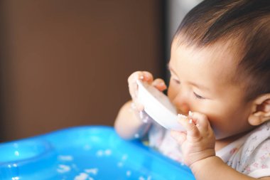 Tek başına yemek yeme Asya bebek