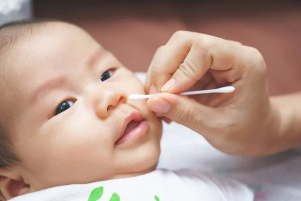 Mère nettoyer les oreilles et le nez du bébé — Photo