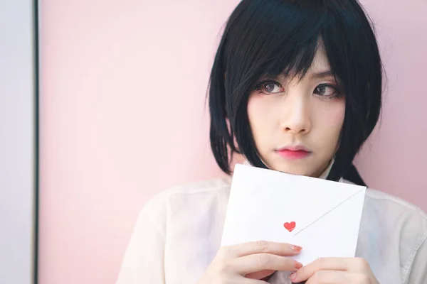 Asiatisk tjej i uniform med kärleksbrev — Stockfoto
