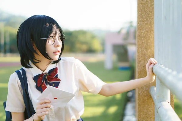 Asiatisk tjej i uniform med kärleksbrev — Stockfoto