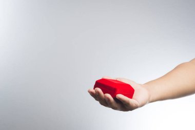 Bir adam bir kırmızı kadife kutu tutan el