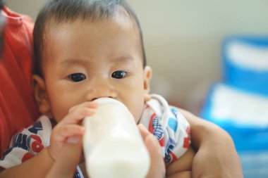 Şişeden içme sütü Asyalı çocuk ağlıyor