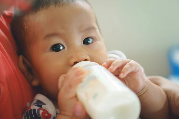 Llorando asiático niño bebiendo leche de botella — Foto de Stock