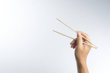 Bambu yapılmış tek kullanımlık ahşap çubuk tutan el