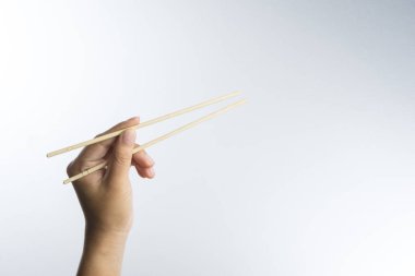 Bambu yapılmış tek kullanımlık ahşap çubuk tutan el