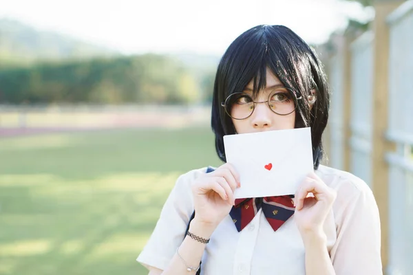 Aşk mektubu ile üniformalı Asyalı kız — Stok fotoğraf