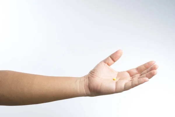 Mână cu pastilă galbenă în palmă — Fotografie, imagine de stoc