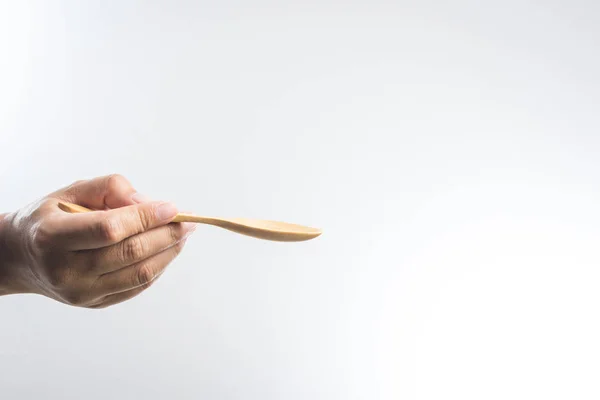 Ο άνθρωπος χέρι κρατά ένα ξύλινο κουτάλι — Φωτογραφία Αρχείου