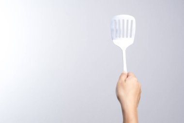 Tava paslanmaz kürek tutan el