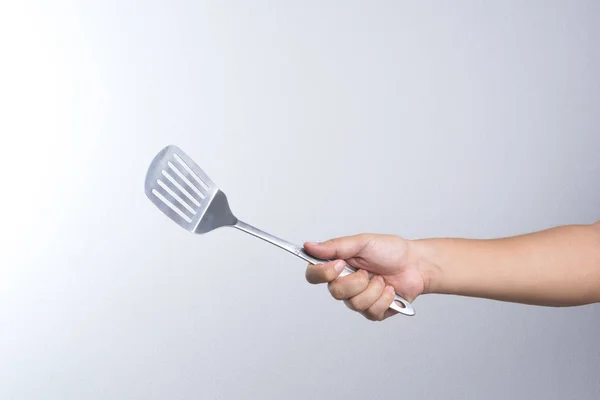 Рука тримає нержавіючу ложку сковороди — стокове фото