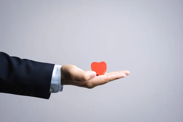 Hombre de negocios mano con madera corazón rojo objeto —  Fotos de Stock