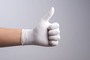 El başparmak yukarı hareketi ile lateks eldiven giymiş