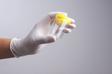 Lateks eldiven boş idrar plastik konteyner tutan eliyle