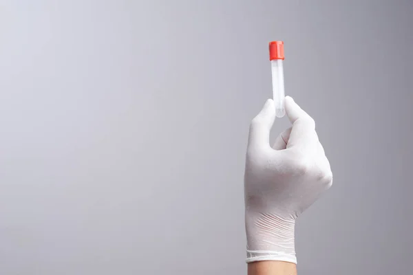 Hand with latex glove holding empty test tube — Stock Photo, Image