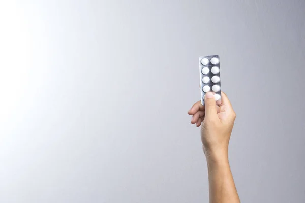 Een hand van de man met witte geneeskunde pillen onder blister — Stockfoto