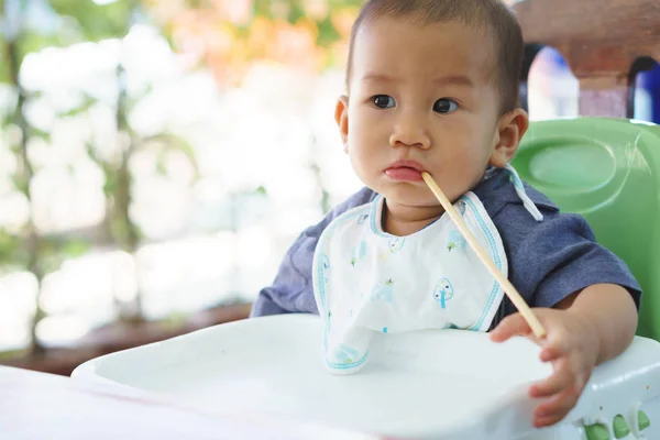 Asiático bebê comer comida por si mesmo — Fotografia de Stock