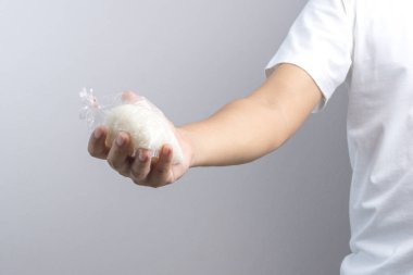 Lastik bant, bir ordin tarafından mühürlü plastik torba pirinç tutan el