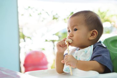 Tek başına yemek yeme Asya bebek