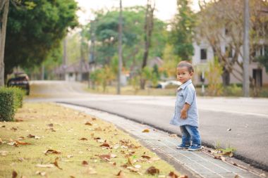 Asyalı çocuk sokağın karşısındaki yürümeyi öğrenme