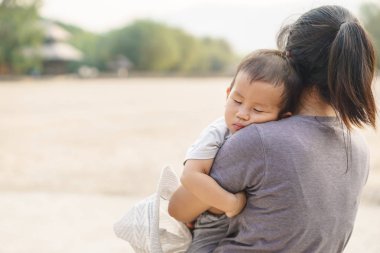 Annesi tarafından tutulan uyuyan Asya bebek