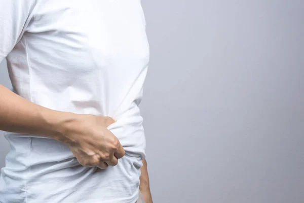 Woman touching her fat belly — Stock Photo, Image