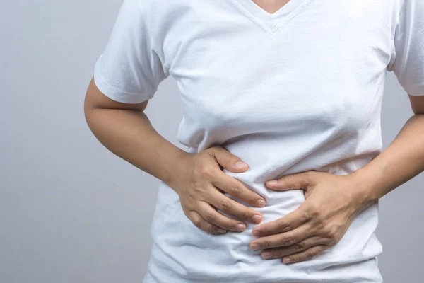 Karın veya mide ağrısı için ellerini koyarak kadın