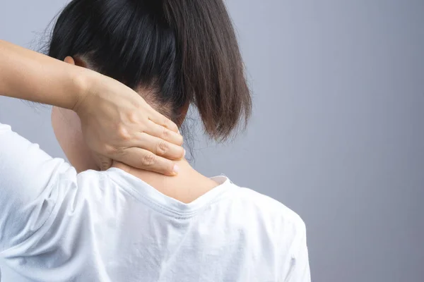 Vrouw zetten haar hand voor nek of rug pijn — Stockfoto