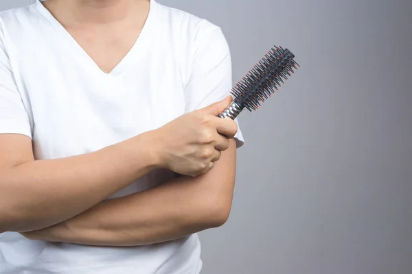 Woman hand holding black round comb or hairbrush — Stock Photo, Image