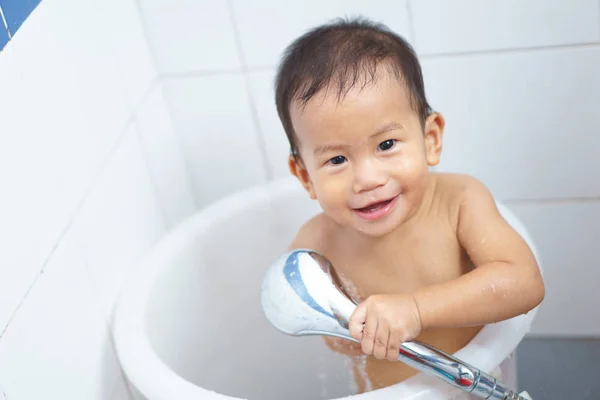 Азиатский ребенок принимает душ сам — стоковое фото