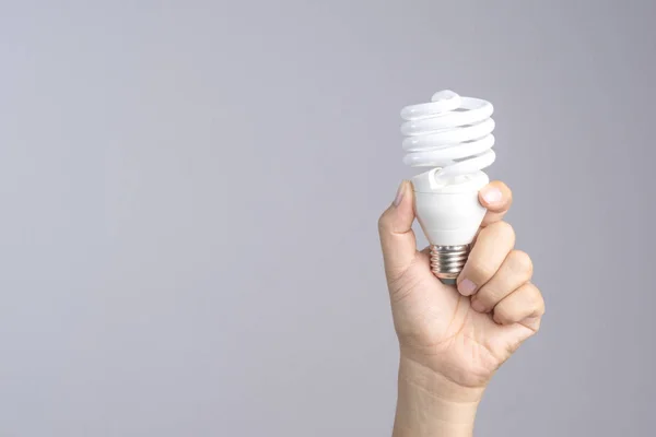 Hand holding compact fluorescent light bulb — Stock Photo, Image