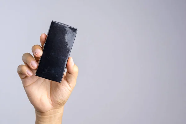 Mão segurando caixa de papel preto — Fotografia de Stock