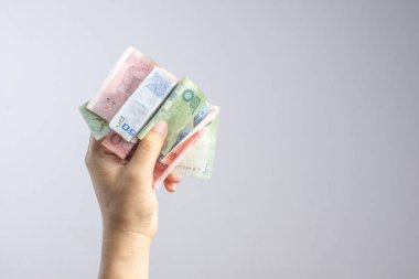 Tayland para ya da banknot tutan el