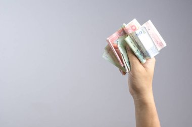 Tayland para ya da banknot tutan el