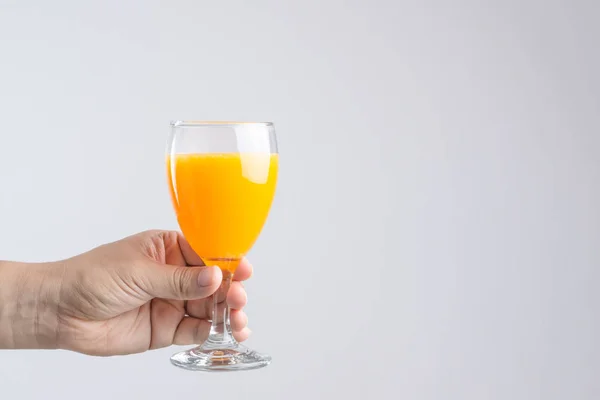 Mão segurando vidro de suco de laranja — Fotografia de Stock